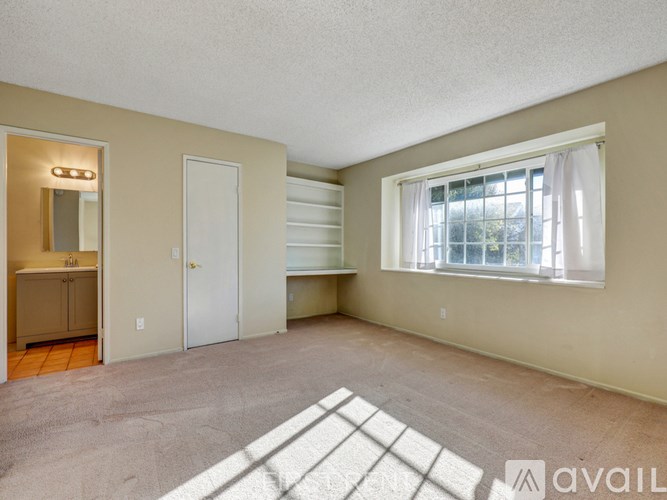 A staircase with a carpeted floor and a chandelier hanging from the ceiling.