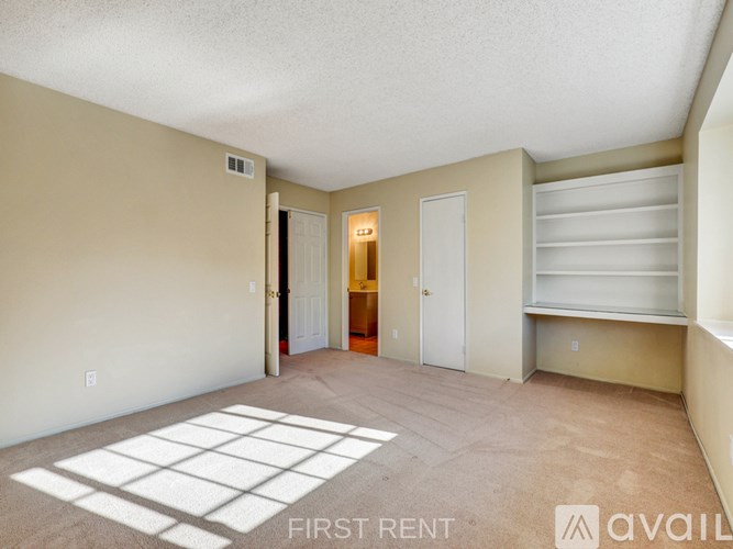 A room with a carpeted floor and a door leading outside.
