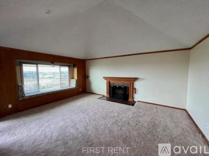 A living room with a fireplace and a window.