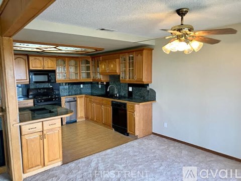 A kitchen with wooden cabinets and a black countertop.