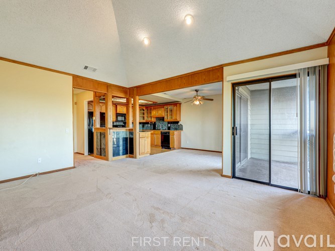 A kitchen with wooden cabinets and black countertops is available for rent.