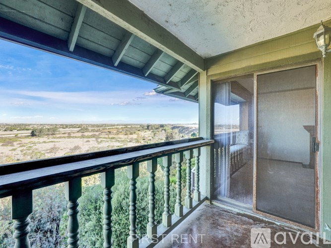 A room with a staircase and a doorway leading to another room.