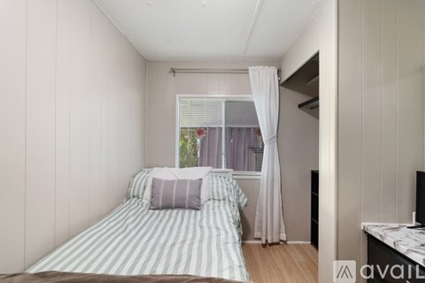 A bedroom with a bed and a window with curtains.