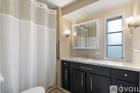 A bathroom with a white shower curtain and a white toilet.
