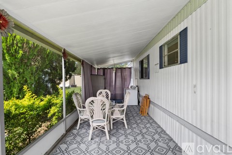 A patio with a table and chairs overlooking a garden.