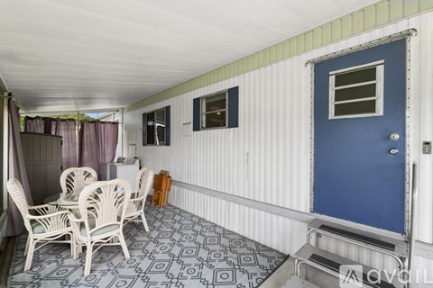 A blue door is on the right side of a white wall.