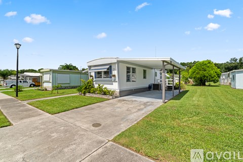 A house with a white exterior and a green lawn in front.