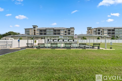 A large building with a grassy area in front and a clear blue sky above.