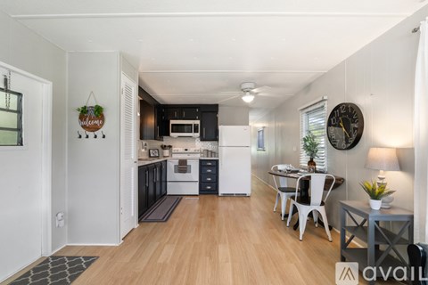 A kitchen with a dining table and chairs.