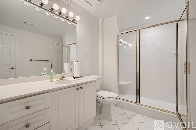 A white bathroom with a toilet, sink, and mirror.