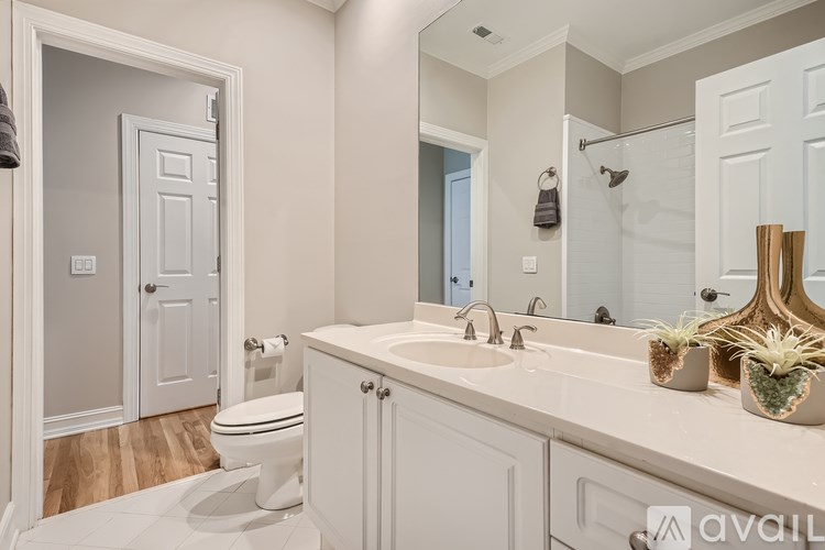 A bathroom with a toilet, sink, and mirror.