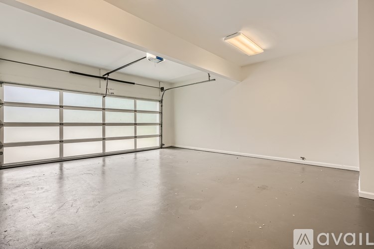 A spacious room with a large window and a garage door.