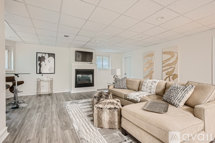 A living room with a beige couch and a fireplace.