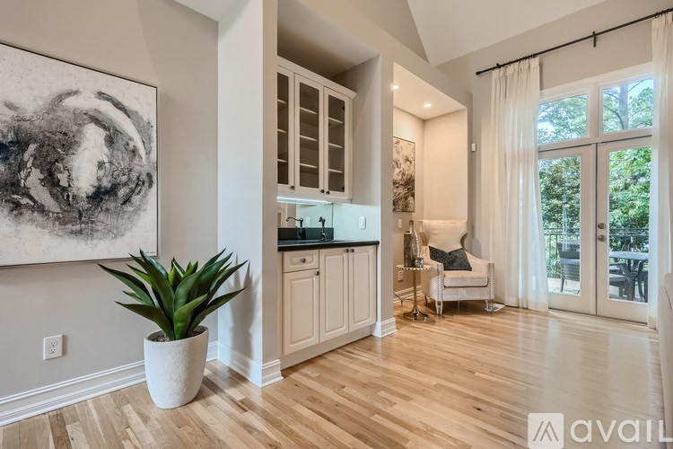 A living room with a large painting on the wall and a plant in a white pot.