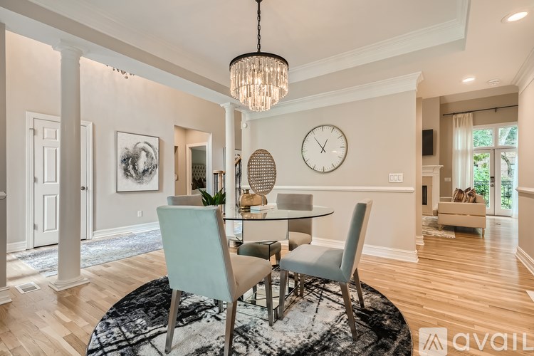 A dining room with a table set for two and a chandelier hanging from the ceiling.