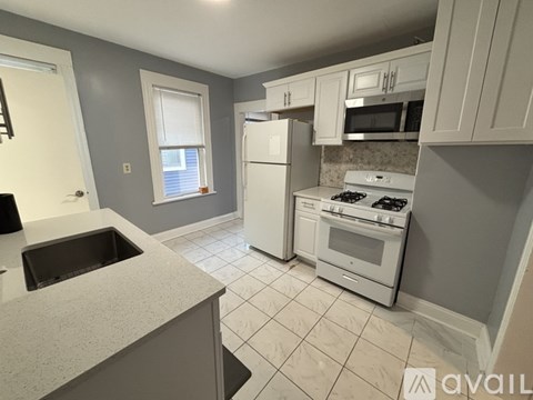 A kitchen with a sink, stove, and refrigerator.