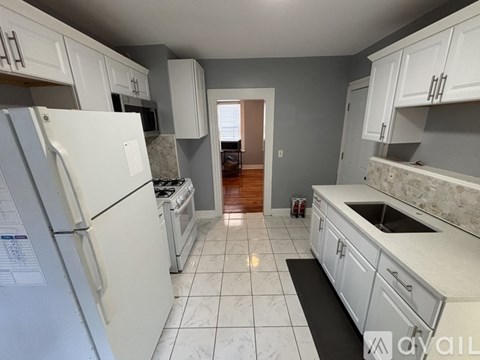 A kitchen with white appliances and cabinets.