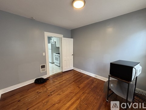 A room with wooden flooring and a television on a stand.