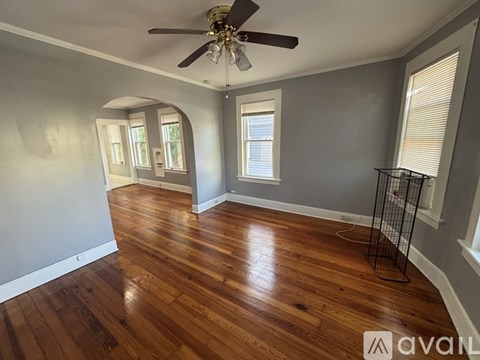 A room with wooden floors and a ceiling fan.