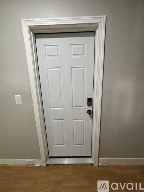 A white door with a black handle is set in a white frame.