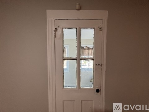 A white door with a glass window is in a room.