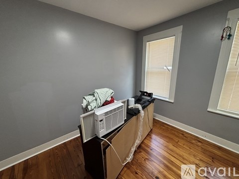 A room with a window and a fan on a table.