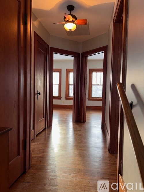 A hallway with wooden floors and doors on both sides.