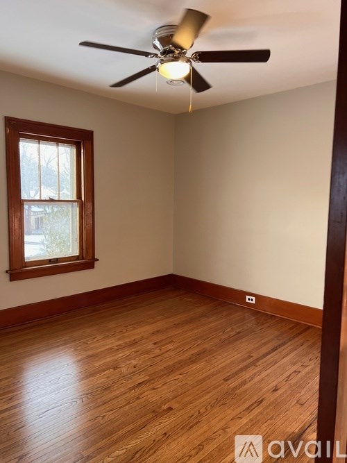 A room with a ceiling fan and a window.