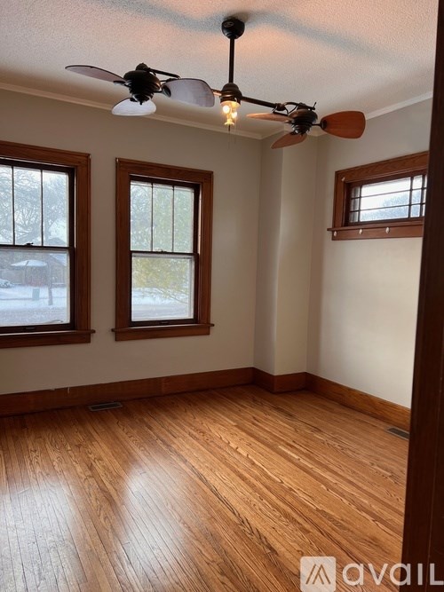 A room with wooden floors and a ceiling fan.