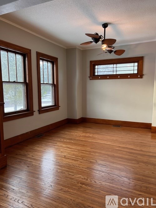 A room with wooden floors and a ceiling fan.