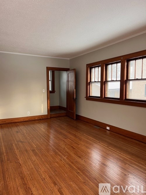 A room with wooden floors and a window with blinds.