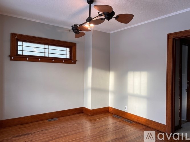A room with a ceiling fan and a window.