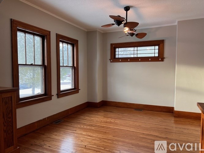 A room with wooden floors and a ceiling fan.