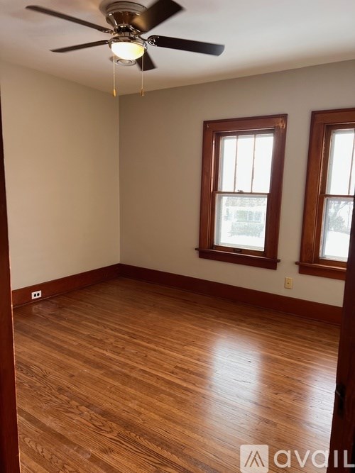 A room with wooden floors and a ceiling fan.