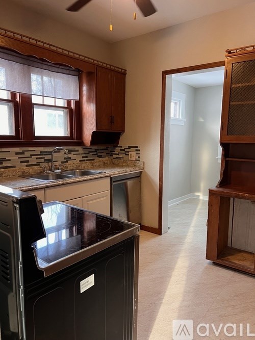 A kitchen with a black oven and a fan on the ceiling.