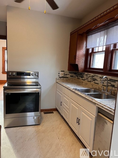A kitchen with a stove top oven and a sink.