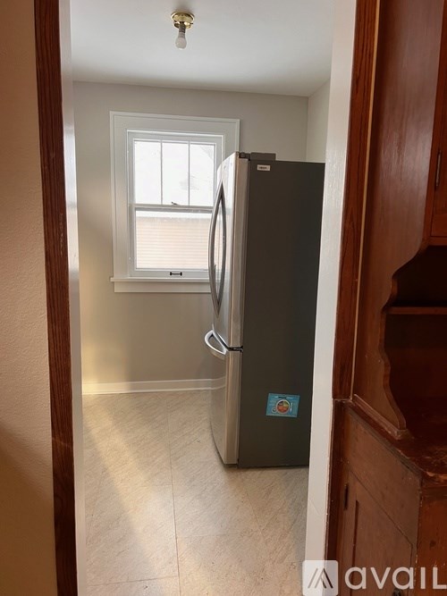 A kitchen with a fridge and a window.