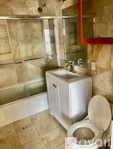 A white toilet sits next to a sink in a bathroom.
