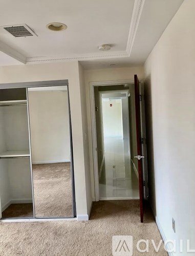 A hallway with a glass door and a mirror on the wall.