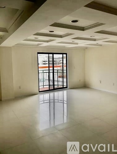 A spacious room with a large window and a view of a building outside.