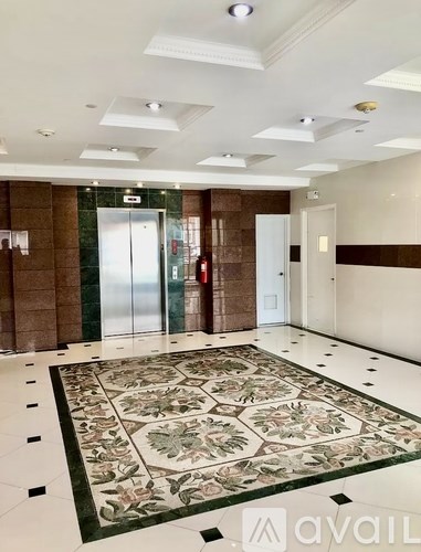A hallway with a tiled floor and a glass door.