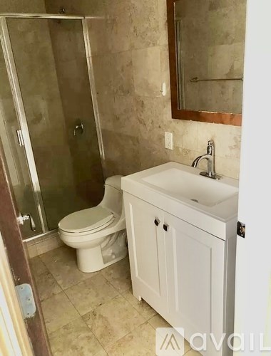 A bathroom with a toilet, sink, and shower.