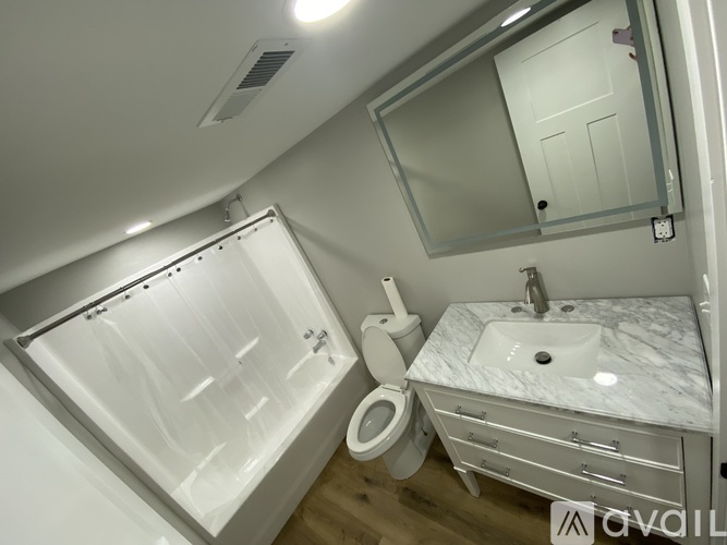 A modern bathroom with a walk-in shower, toilet, and sink.