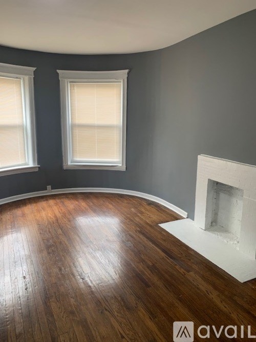 A room with a fireplace and wood flooring.