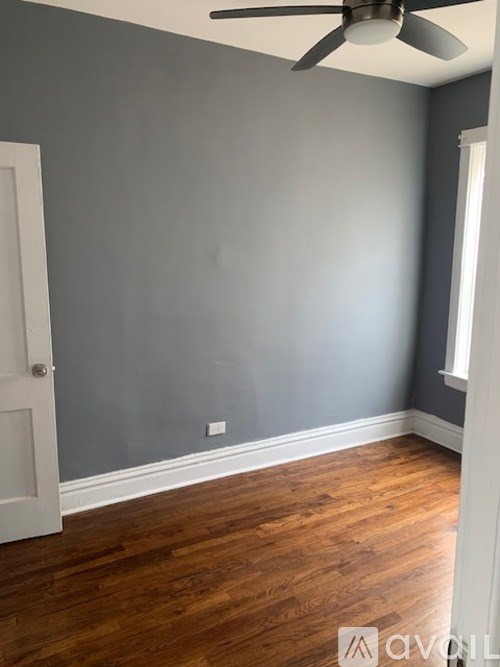 A room with a ceiling fan and a door.