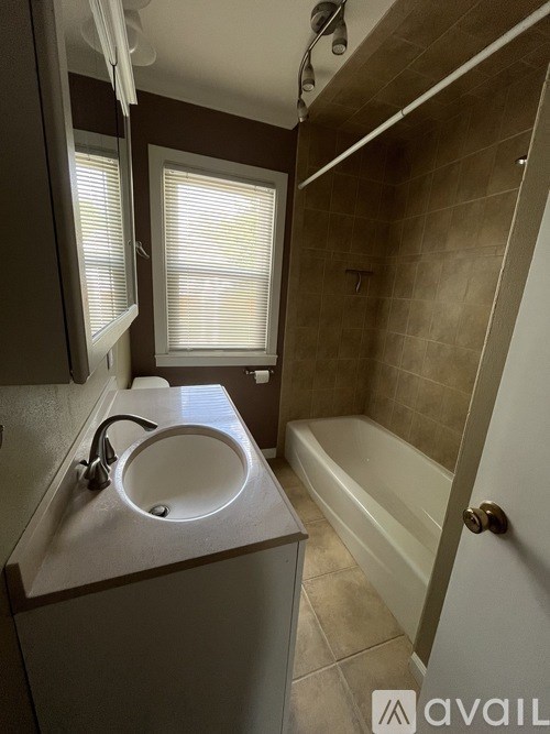 A bathroom with a sink, mirror, and bathtub.