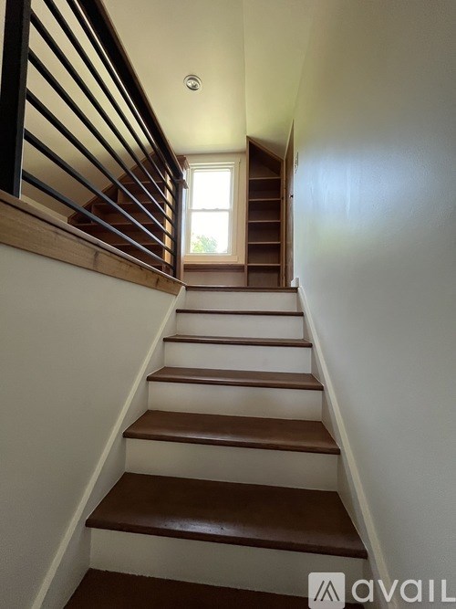 A staircase with wooden steps and a window at the top.
