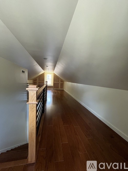 A long hallway with wooden floors and white walls.