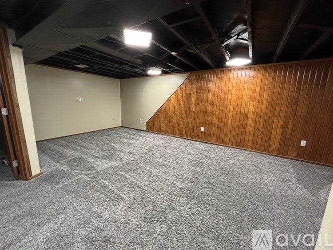 A room with a carpeted floor and a wooden wall.