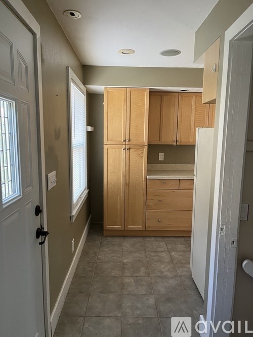 A kitchen with wooden cabinets and a white door.